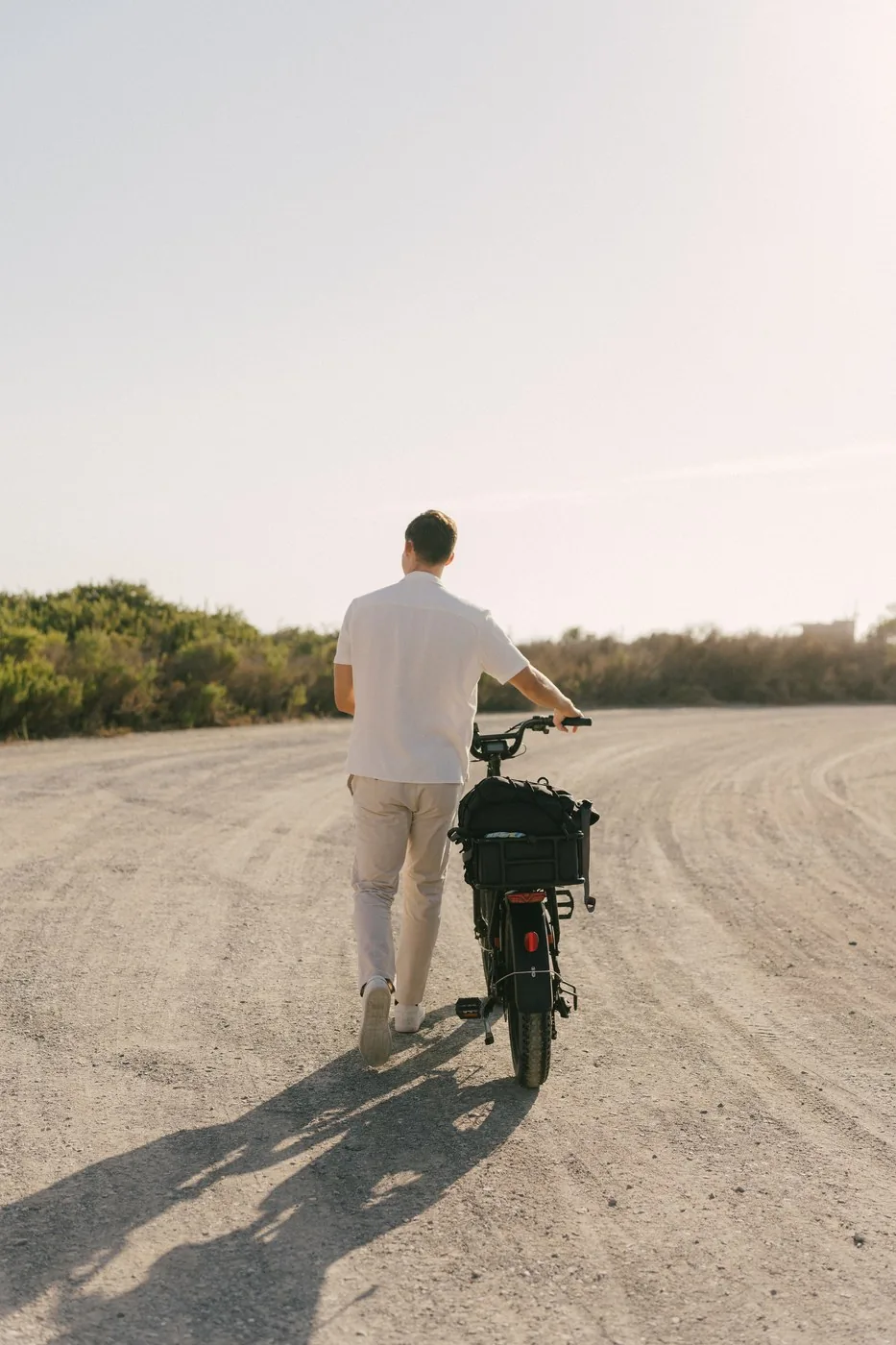 Cameron walking the bike up the dirt track, alone, before she arrived