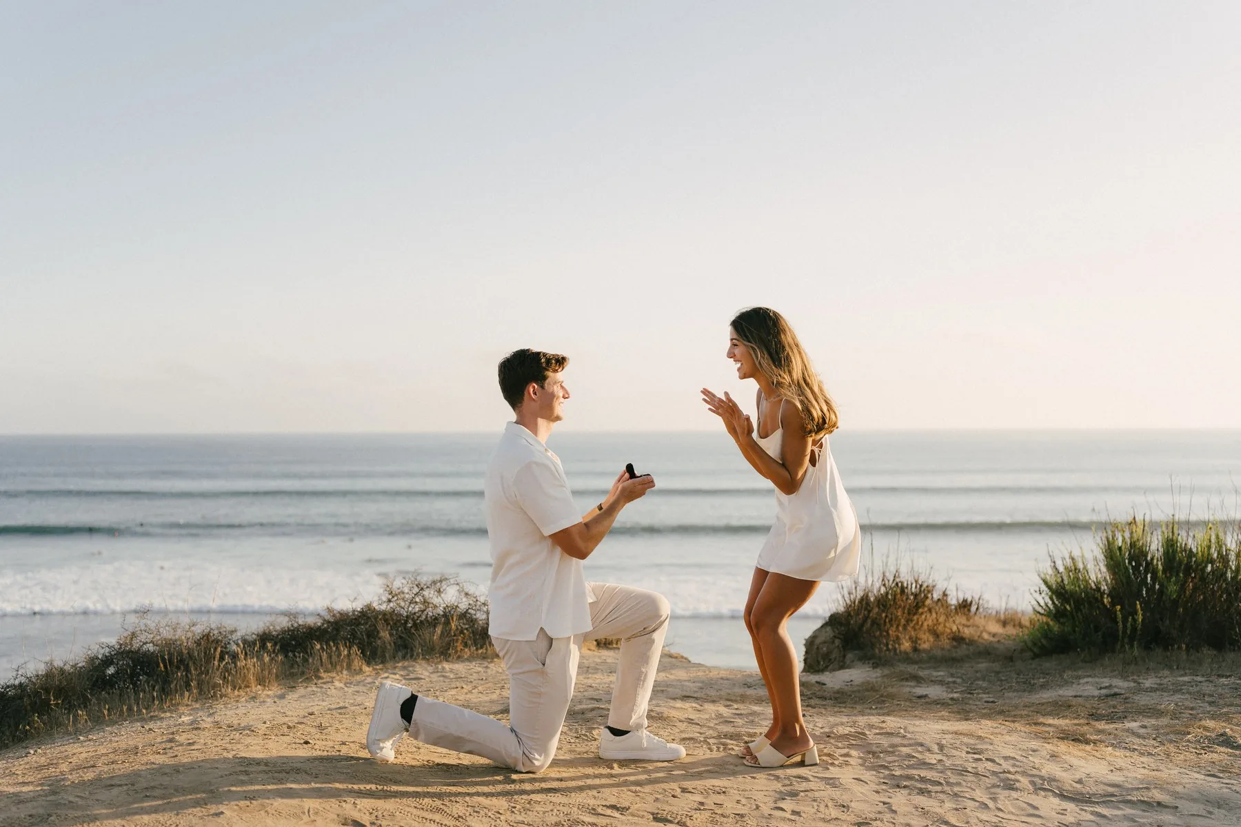 Cameron on one knee above the ocean at San Onofre