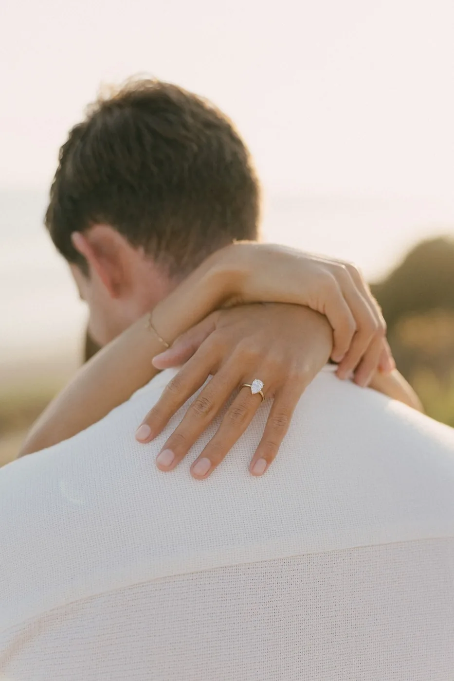 Her hand on his shoulder, the ring on it