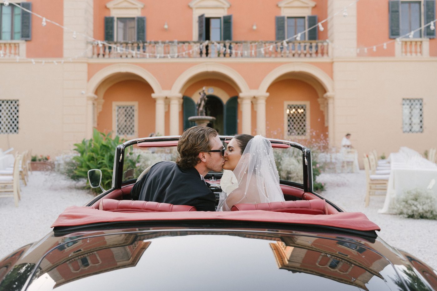 In the car, in front of the villa