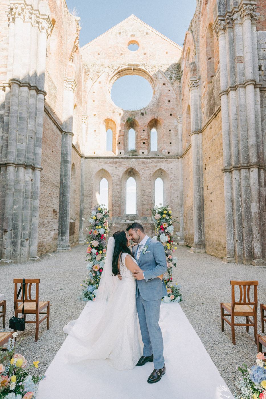 The couple beneath the abbey's Gothic arches, open to the sky