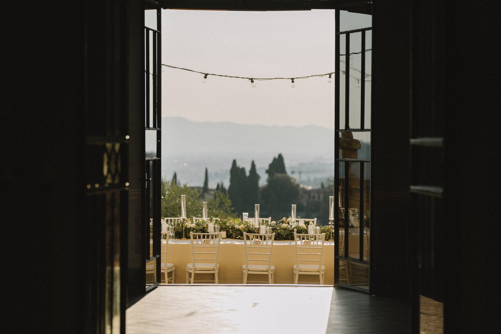The doors, open onto the cypresses