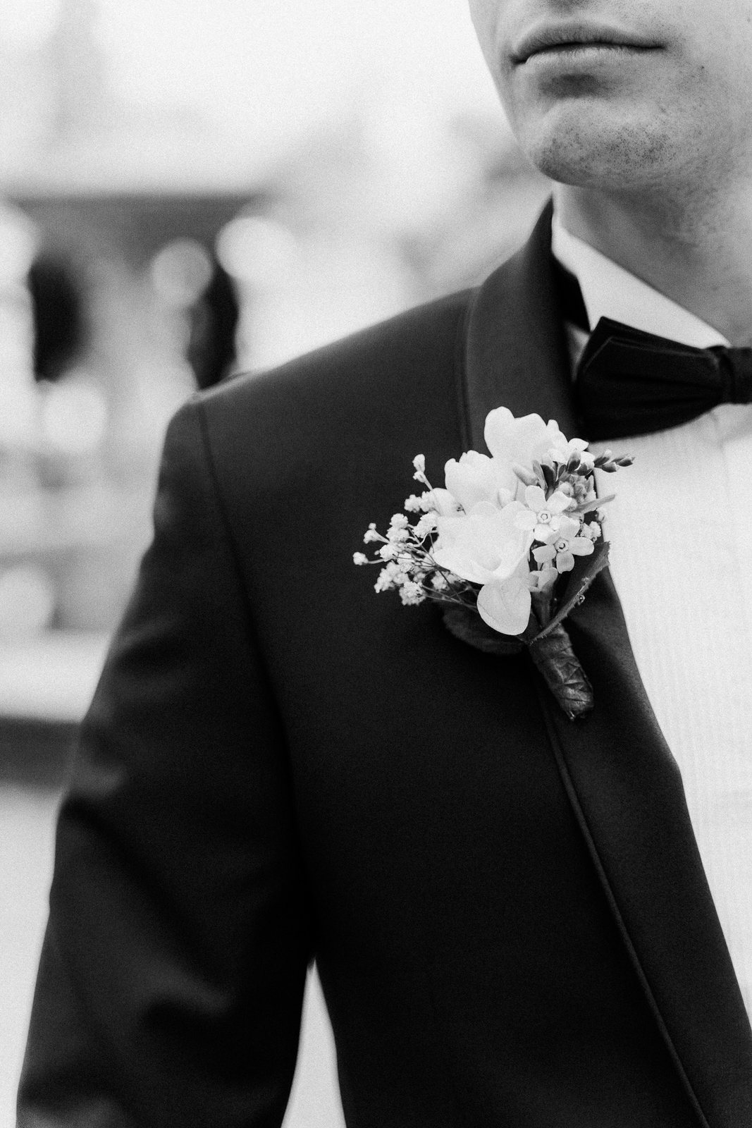 A boutonniere against a dark jacket — after the preset