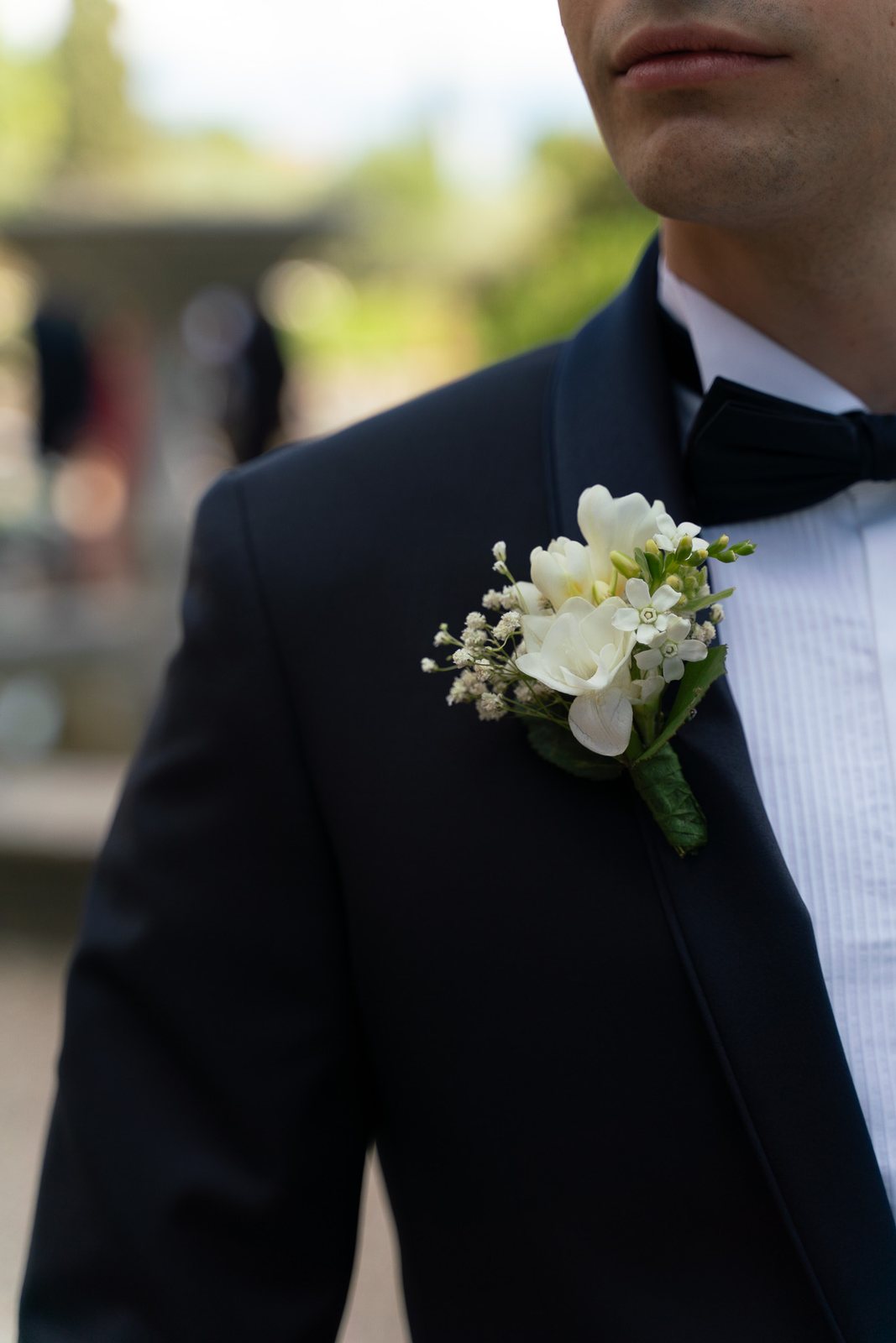 A boutonniere against a dark jacket — before the preset