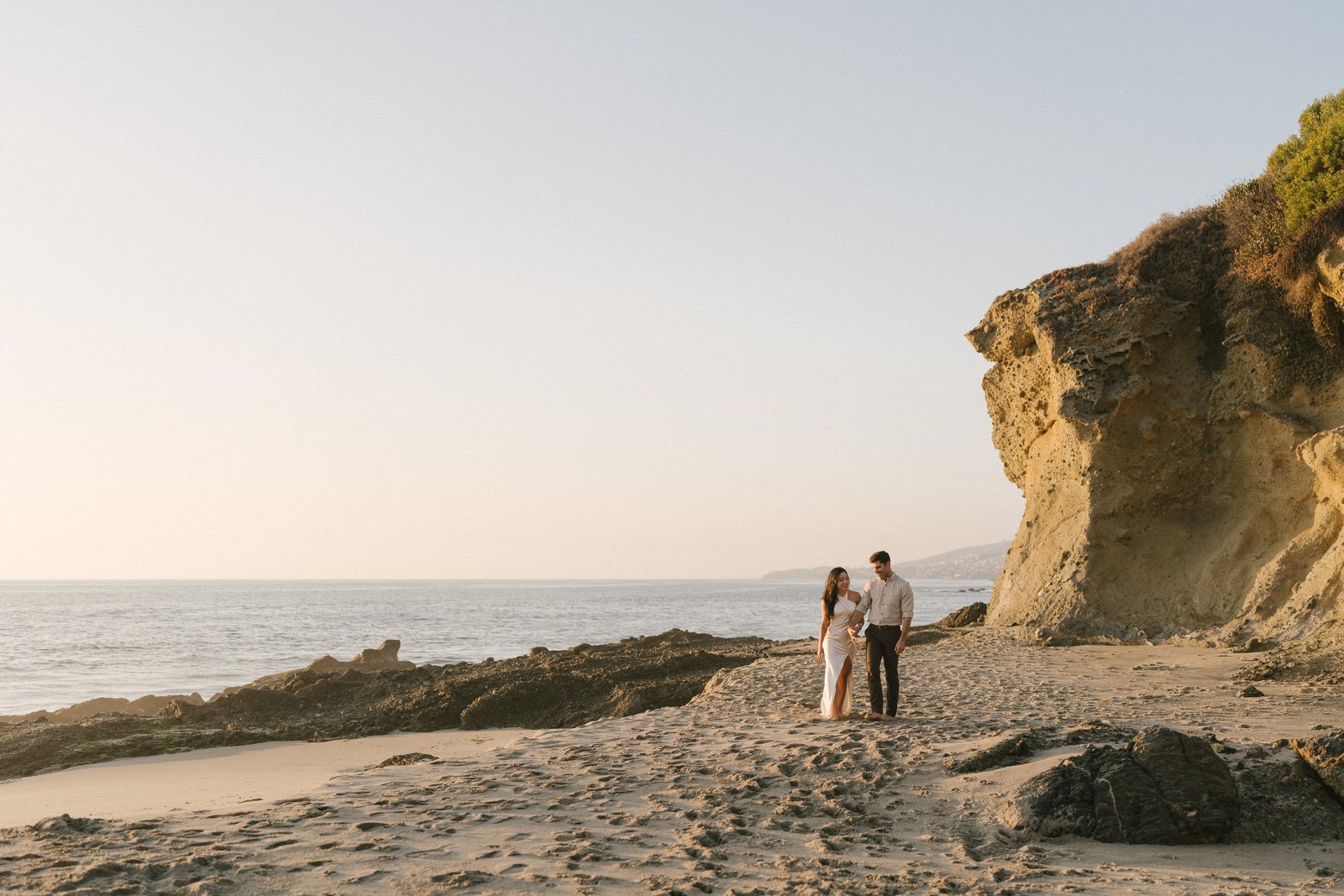 A couple on the rocks at Laguna Beach at sunset
