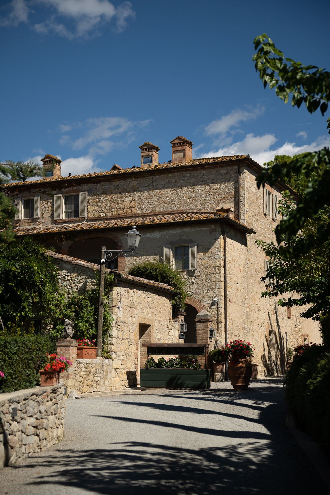 A stone villa under a hard midday sky — before the preset